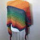 A crocheted shawl made with rainbow gradient yarn.  50% cotton, 50% acrylic.