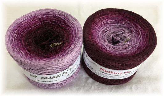 2 cakes of the Wolltraum My Melodyy gradient yarn colourway Blackberry Way.  It goes from lavender purple to a deep red/purple.