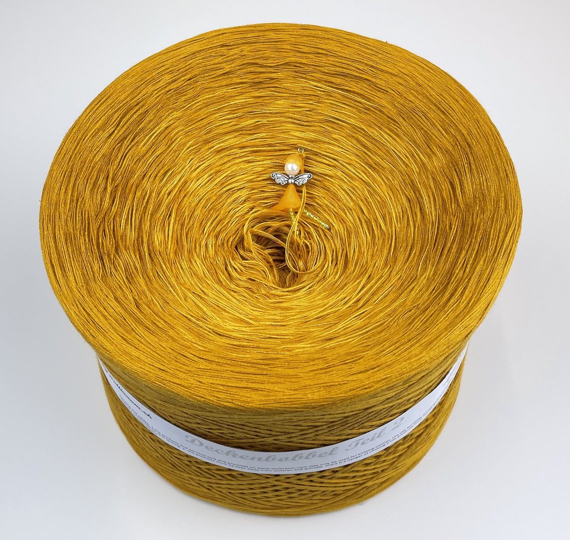 A large Wolltraum yarn cake in a deep yellow.